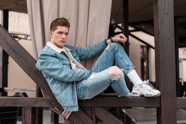 Jovem bonito em roupas de calça jeans casual da moda em elegantes