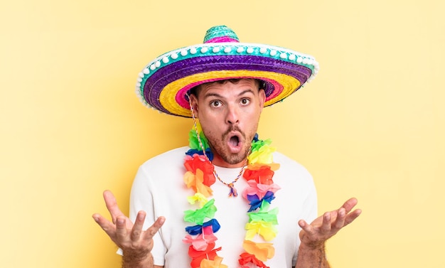 Jovem bonito espantado, chocado e surpreso com uma surpresa inacreditável. conceito de festa mexicana