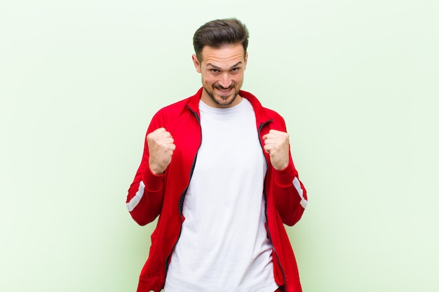 Jovem bonito esportes homem ou monitor, sentindo-se chocado, animado e feliz, rindo e comemorando o sucesso, dizendo uau