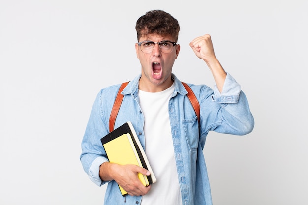 Jovem bonito gritando agressivamente com uma expressão de raiva. conceito de estudante universitário