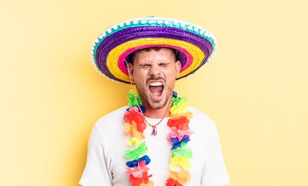 Jovem bonito gritando agressivamente, parecendo muito zangado. conceito de festa mexicana