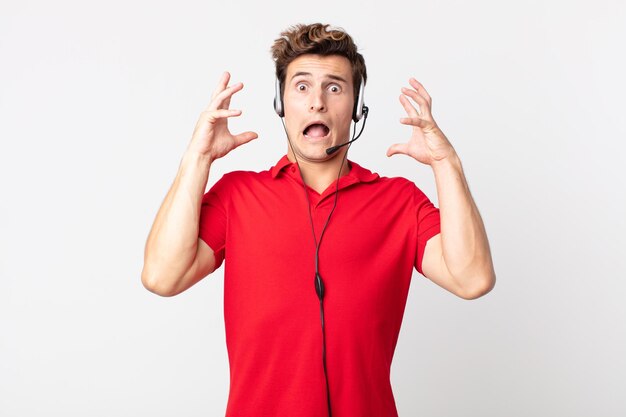 jovem bonito gritando com as mãos no ar. conceito de telemarketing