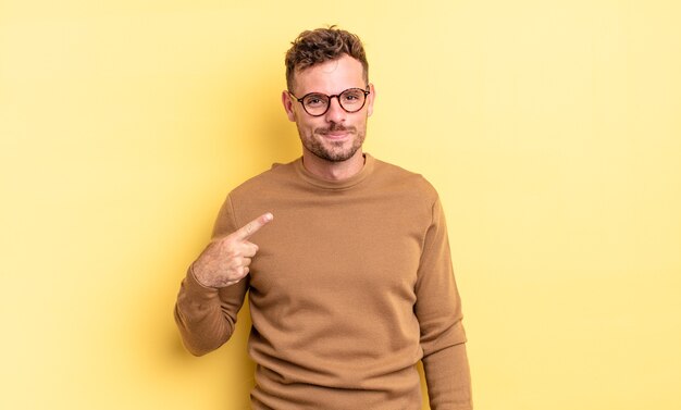 jovem bonito hispânico parecendo orgulhoso, confiante e feliz, sorrindo e apontando para si mesmo ou fazendo o primeiro sinal