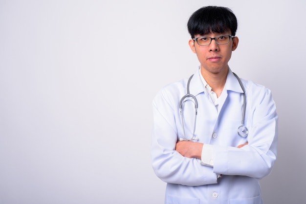 jovem bonito homem asiático médico contra uma parede branca
