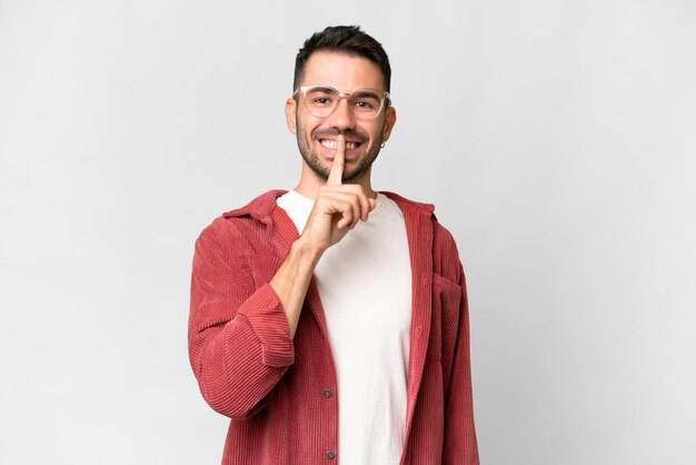 Jovem bonito homem caucasiano sobre fundo branco isolado, mostrando um sinal de gesto de silêncio, colocando o dedo na boca