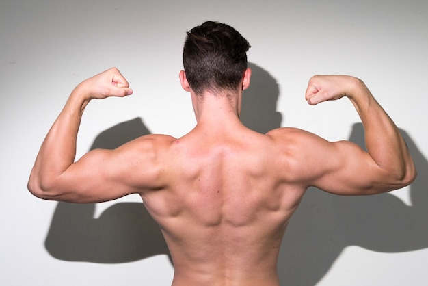 Jovem bonito homem musculoso com cabelo castanho sem camisa