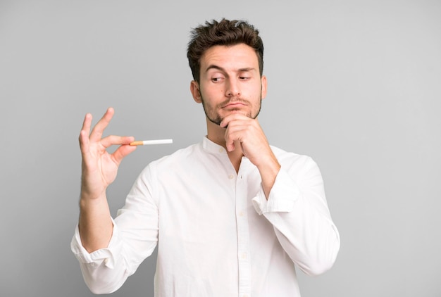 Jovem bonito isolado e segurando um cigarro