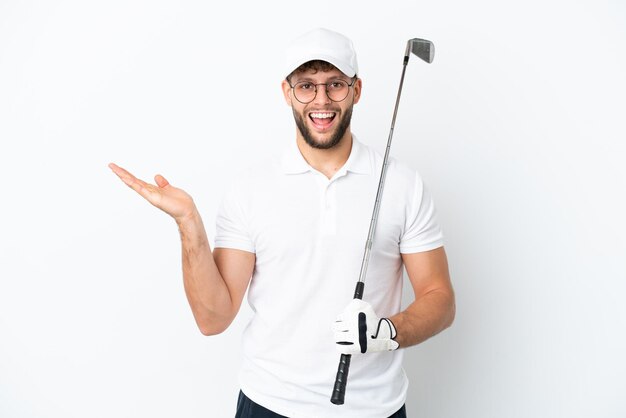 Jovem bonito jogando golfe isolado no fundo branco com expressão facial chocada