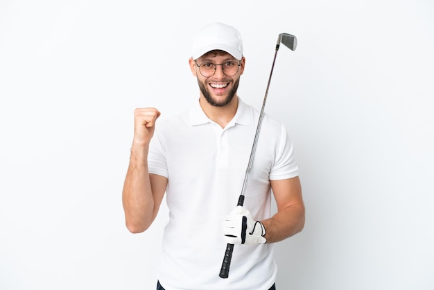 Foto jovem bonito jogando golfe isolado no fundo branco comemorando uma vitória na posição de vencedor