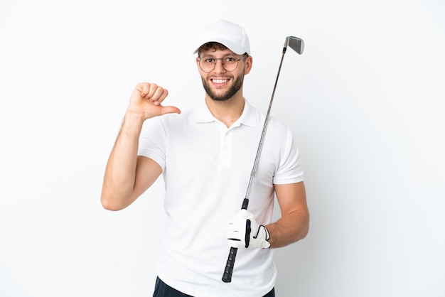 Jovem bonito jogando golfe isolado no fundo branco orgulhoso e satisfeito