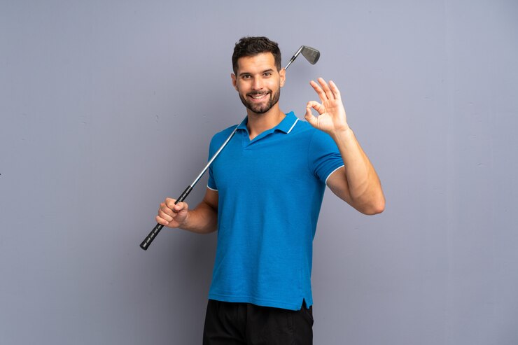 Foto jovem bonito jogando golfe mostrando sinal de ok com os dedos