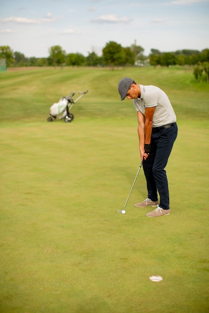 Jovem bonito jogando golfe