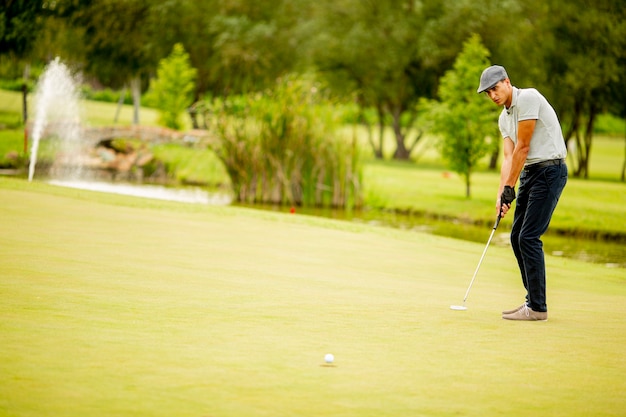 Jovem bonito jogando golfe