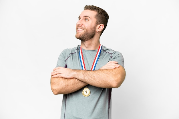 Jovem bonito loiro com medalhas sobre fundo branco isolado feliz e sorridente