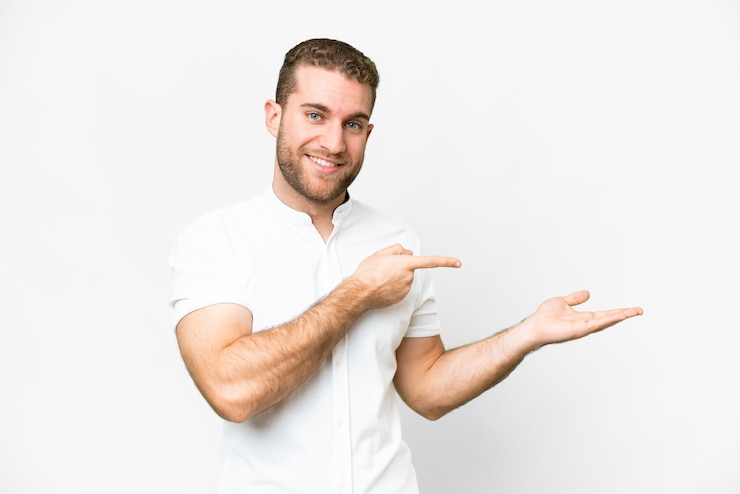 Foto jovem bonito loiro sobre fundo branco isolado, segurando copyspace imaginário na palma da mão para inserir um anúncio