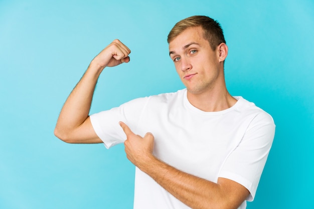 Jovem bonito mostrando força gesto com os braços