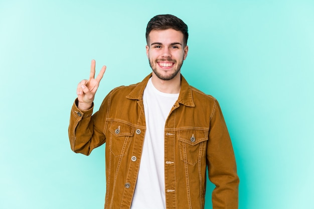 Jovem bonito mostrando sinal de vitória e sorrindo amplamente.