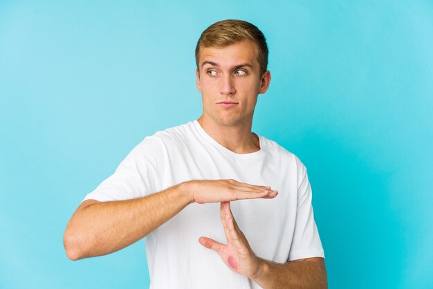 Jovem bonito mostrando um gesto de tempo limite