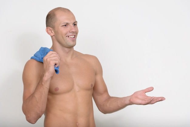 jovem bonito musculoso careca sem camisa contra o espaço em branco