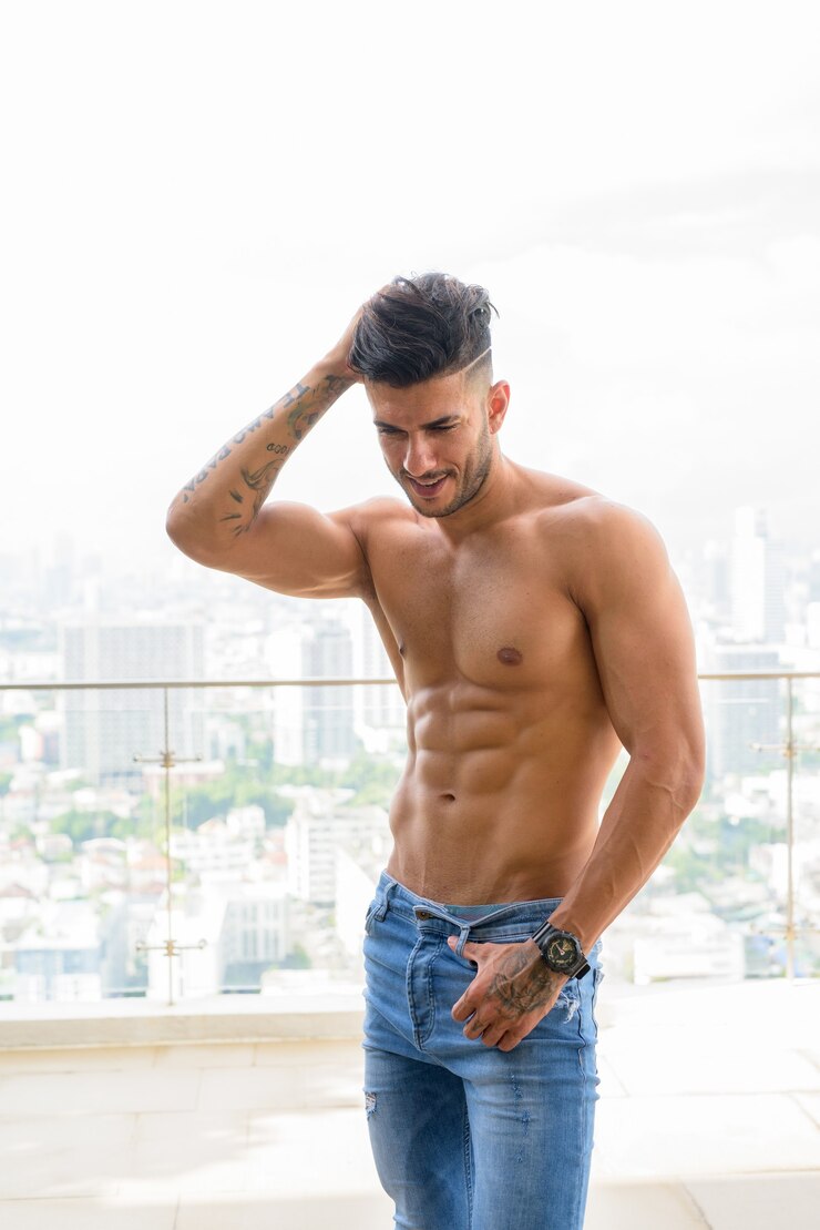Foto jovem bonito musculoso persa feliz sem camisa contra a vista da cidade