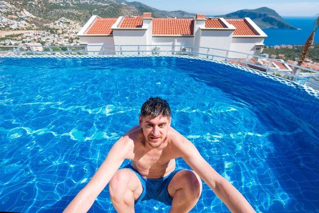 Jovem bonito na beira da piscina