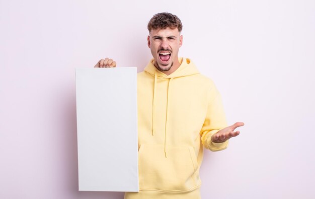 Jovem bonito olhando irritado irritado e frustrado conceito de tela em branco