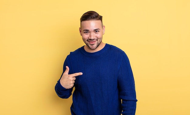 Jovem bonito olhando orgulhoso, confiante e feliz, sorrindo e apontando para si mesmo ou fazendo o sinal número um