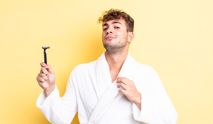 Foto jovem bonito parecendo arrogante, bem sucedido, positivo e orgulhoso. conceito de barbear