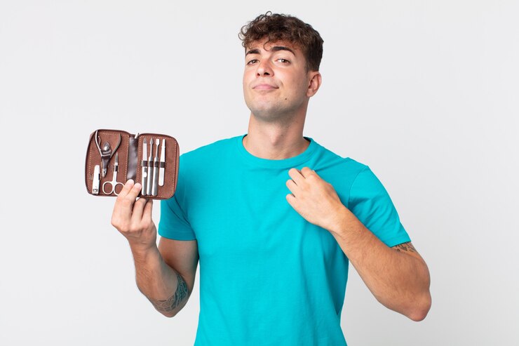 Foto jovem bonito parecendo arrogante, bem-sucedido, positivo e orgulhoso, segurando um estojo de ferramentas de pregos
