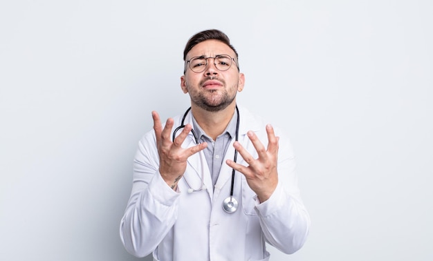 Jovem bonito parecendo desesperado, frustrado e estressado. conceito de médico