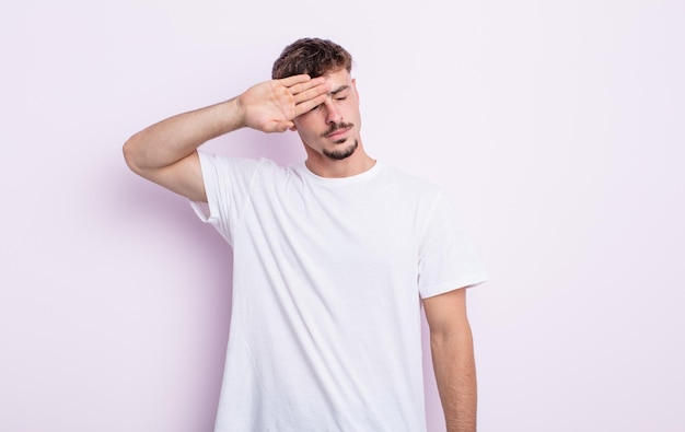 Jovem bonito parecendo estressado, cansado e frustrado, secando o suor da testa, sentindo-se desesperado e exausto