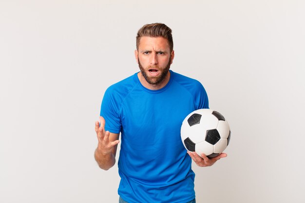 Jovem bonito parecendo zangado, irritado e frustrado. futebol