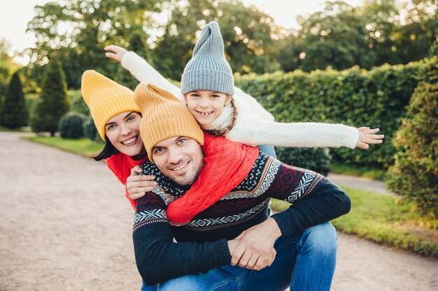 Jovem bonito passa seu tempo livre com a família recebe abraço de filha adorável e linda esposa faz piquenique durante o fim de semana de outono Família afetuosa feliz tem bons relacionamentos