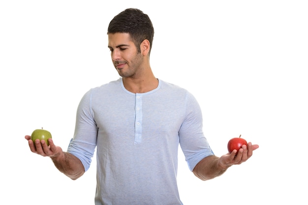 Jovem bonito persa escolhendo entre maçã vermelha e verde