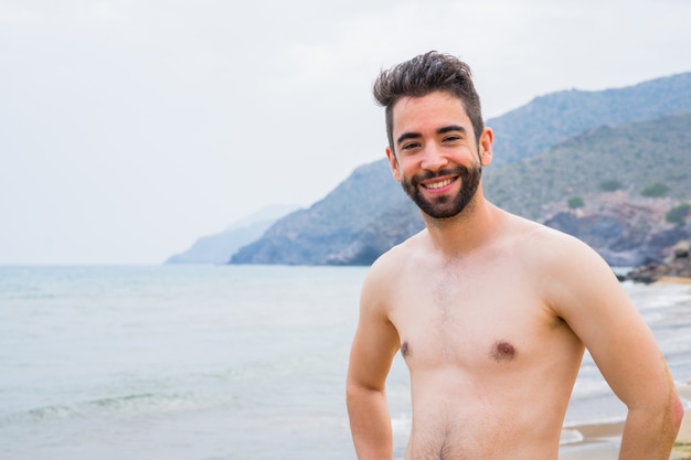 Jovem bonito relaxante na praia