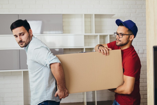 Jovem bonito se mudando para um novo apartamento.