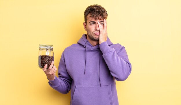 Jovem bonito se sentindo entediado, frustrado e com sono depois de um cansativo. conceito de grãos de café