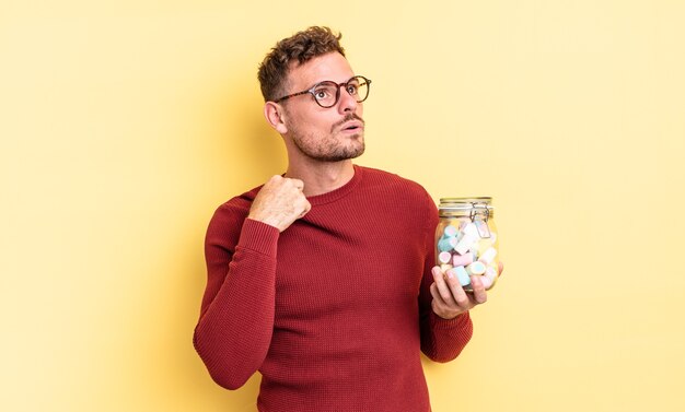 Jovem bonito se sentindo estressado, ansioso, cansado e frustrado. conceito de balas de geleia