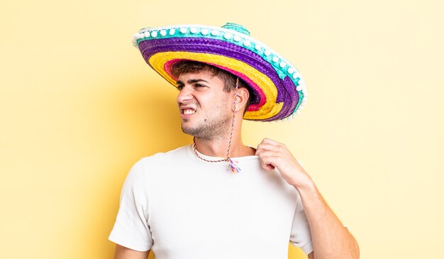 Jovem bonito se sentindo estressado, ansioso, cansado e frustrado. conceito de chapéu mexicano