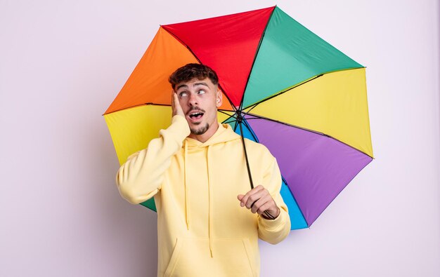 Jovem bonito se sentindo feliz, animado e surpreso. conceito de guarda-chuva