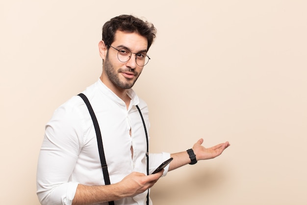 Jovem bonito se sentindo feliz e alegre, sorrindo e dando as boas-vindas, convidando-o com um gesto amigável