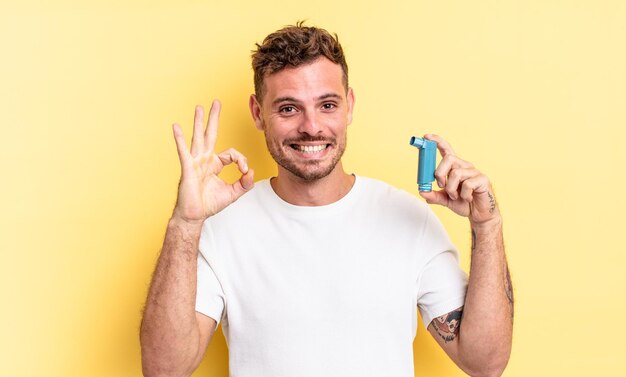 Jovem bonito se sentindo feliz mostrando aprovação com o conceito de asma de gesto bem