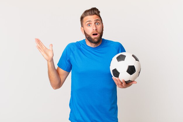 jovem bonito se sentindo feliz, surpreso ao perceber uma solução ou ideia. conceito de futebol