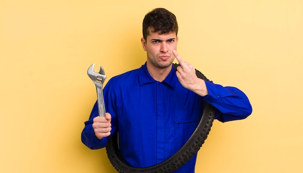 Jovem bonito se sentindo irritado irritado conceito de reparador de bicicleta rebelde e agressivo