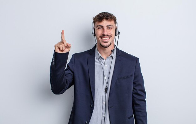 Jovem bonito se sentindo um gênio feliz e animado depois de realizar uma ideia. conceito de telemarketing