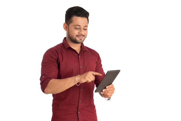 Jovem bonito segurando e usando smartphone ou celular ou tablet em um fundo branco