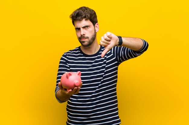 Jovem bonito, segurando um cofrinho