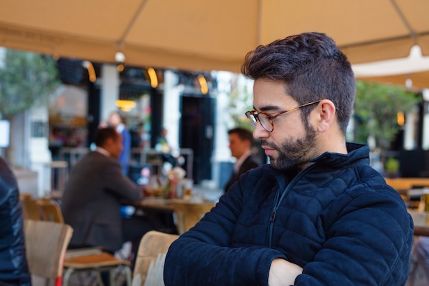 Jovem bonito sentado em um terraço