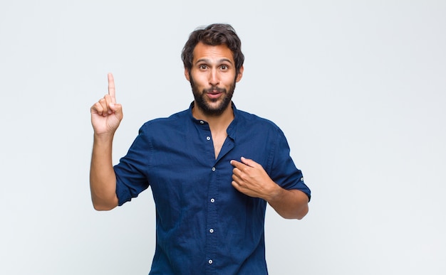 Jovem bonito sentindo-se orgulhoso e surpreso, apontando para si mesmo com confiança, sentindo-se o sucesso número um