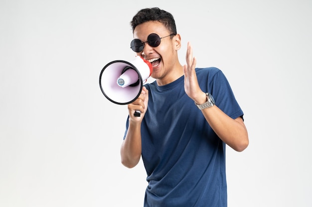 Jovem bonito sobre fundo branco isolado gritando através de um megafone